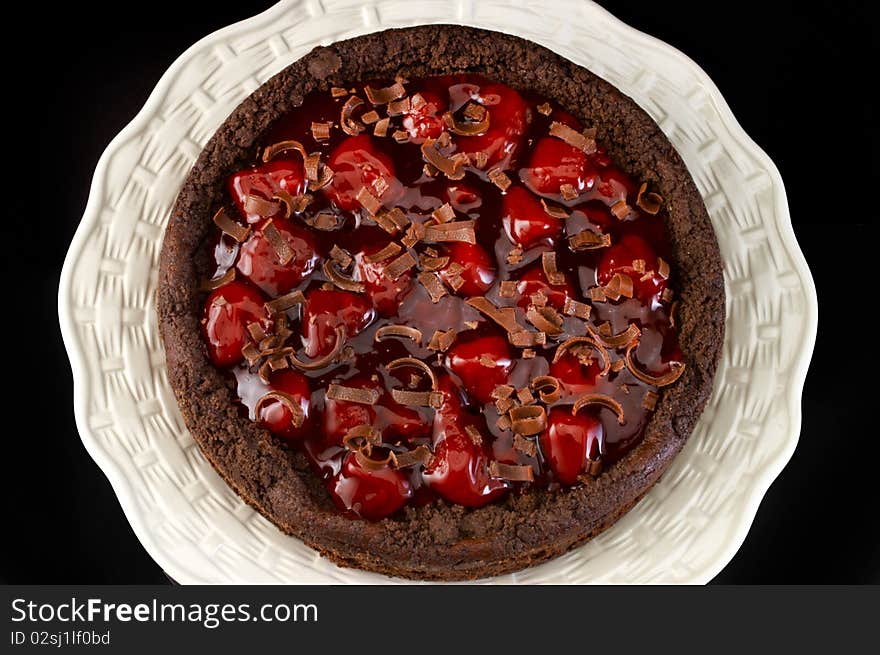 Black forest strawberry cheese cake on white plate with black background