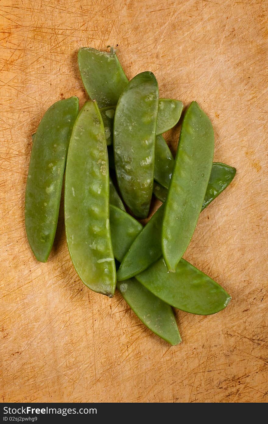 Mange tout on wooden chopping board