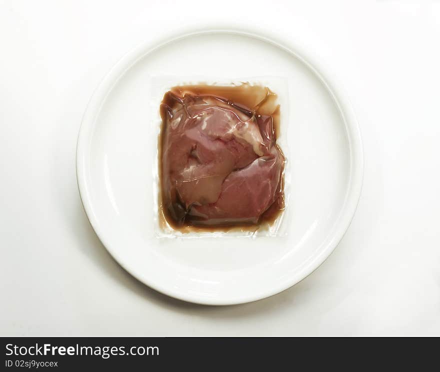 Vacuum packed meat on a plate. Vacuum packed meat on a plate