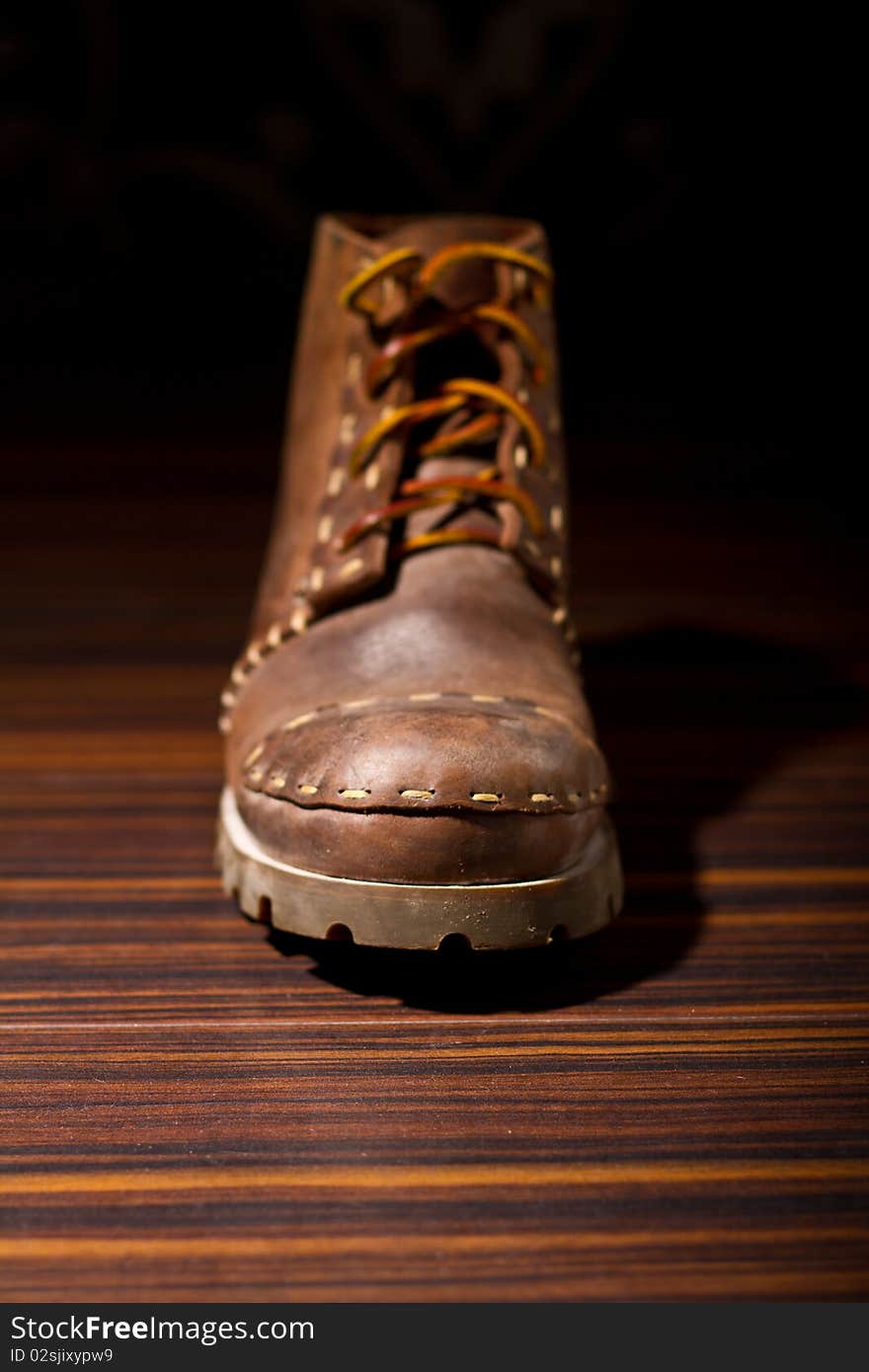 One brown boot on the floor (shallow DOF)