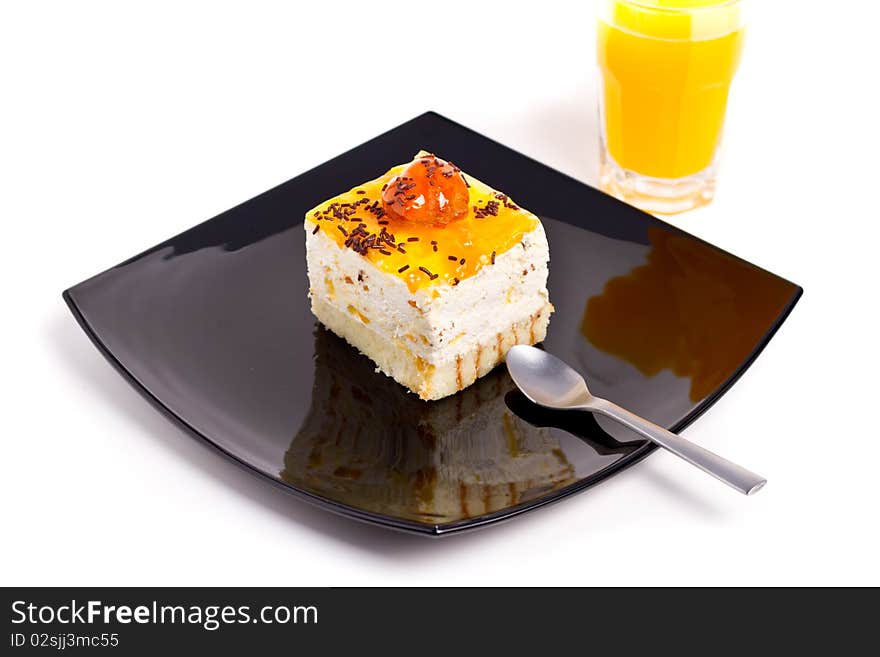 Peach cake on black plate with juice aside