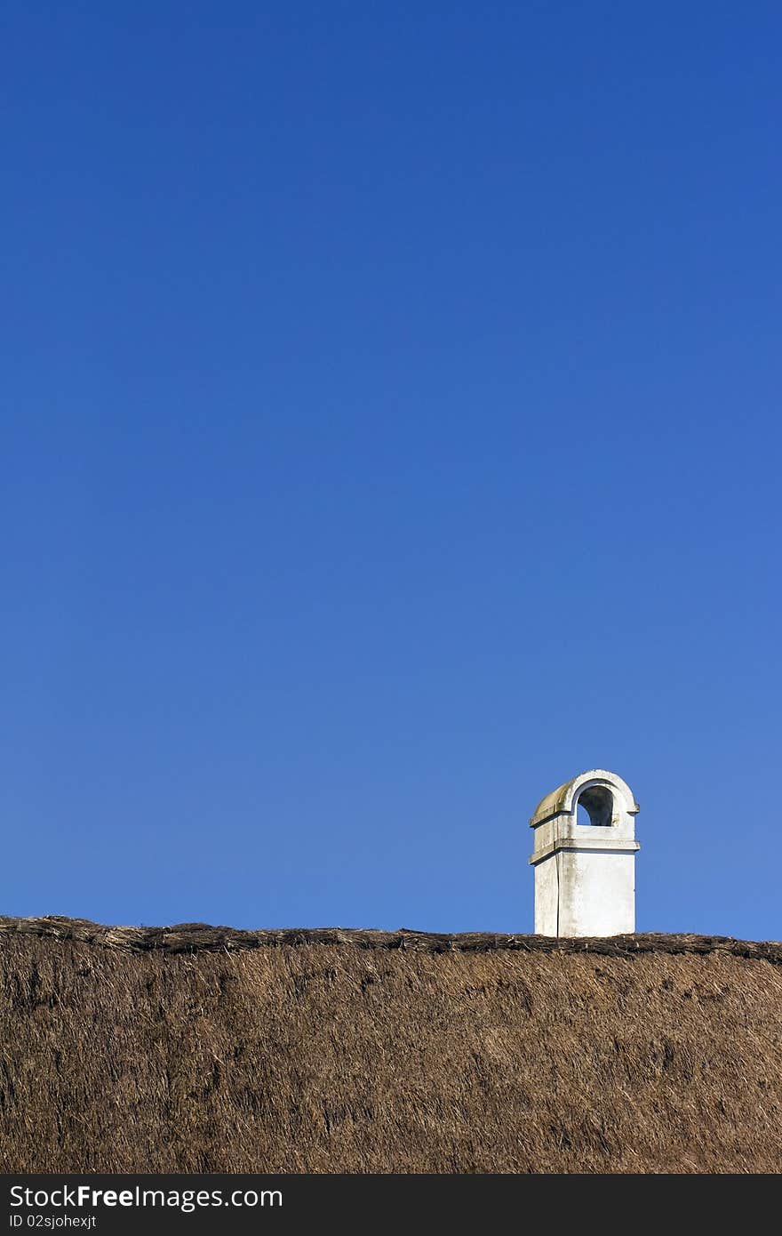 Vintage chimney on rooftop under the clean, blue sky