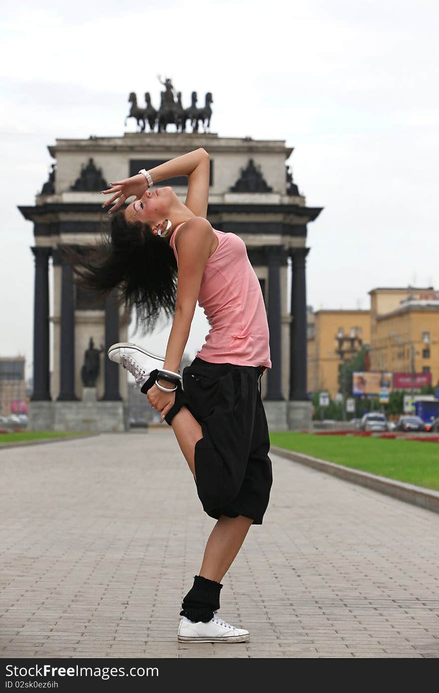 Modern dancer in city against classic arch