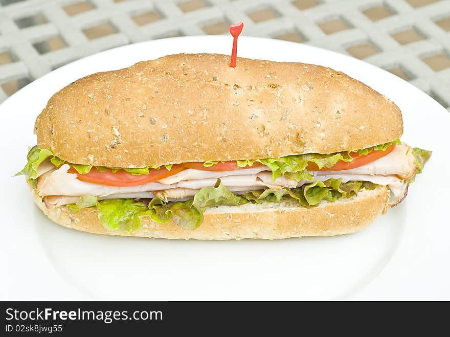 A turkey sandwich with tomato slices and lettuce. A turkey sandwich with tomato slices and lettuce.