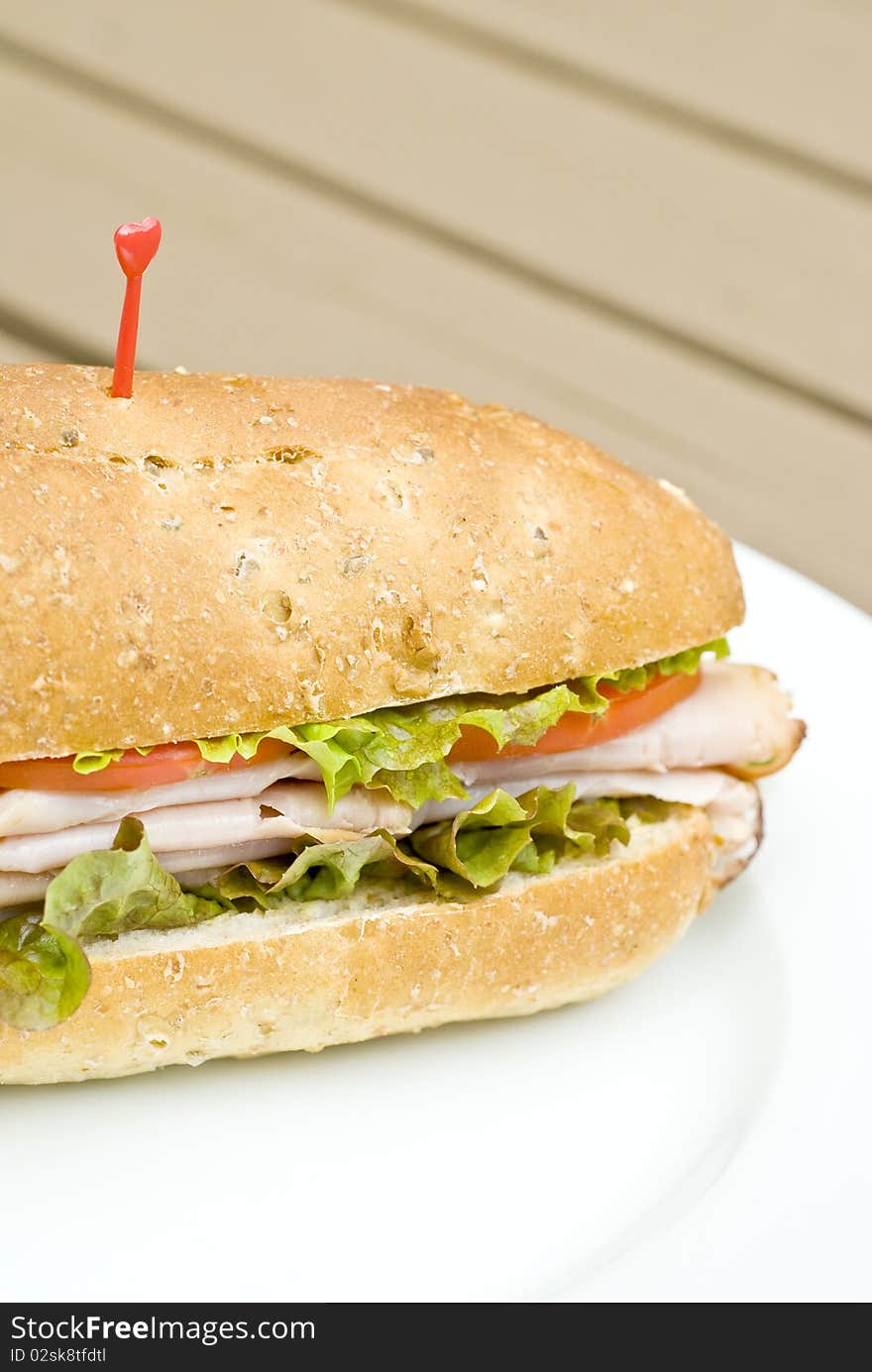 A turkey sandwich with tomato slices and lettuce. A turkey sandwich with tomato slices and lettuce.