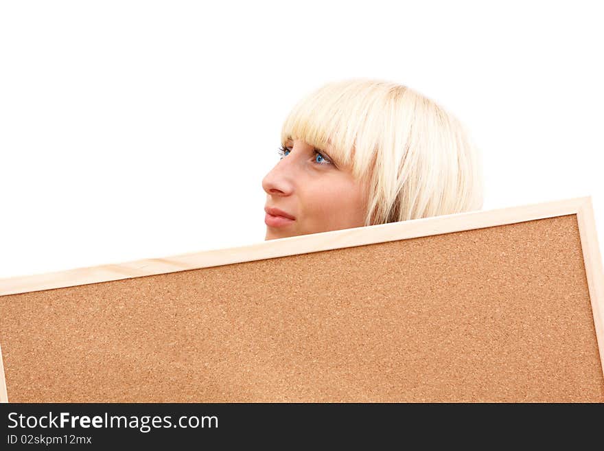 An attractive young woman with blue eyes meditating behind a corkboard. An attractive young woman with blue eyes meditating behind a corkboard