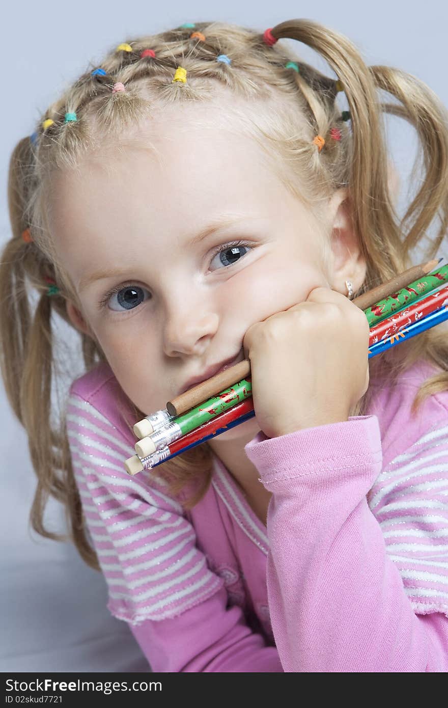 Cute little blond caucasian girl with pencils batch looking appear with calm and thoughtful look concentrated isolated. Cute little blond caucasian girl with pencils batch looking appear with calm and thoughtful look concentrated isolated