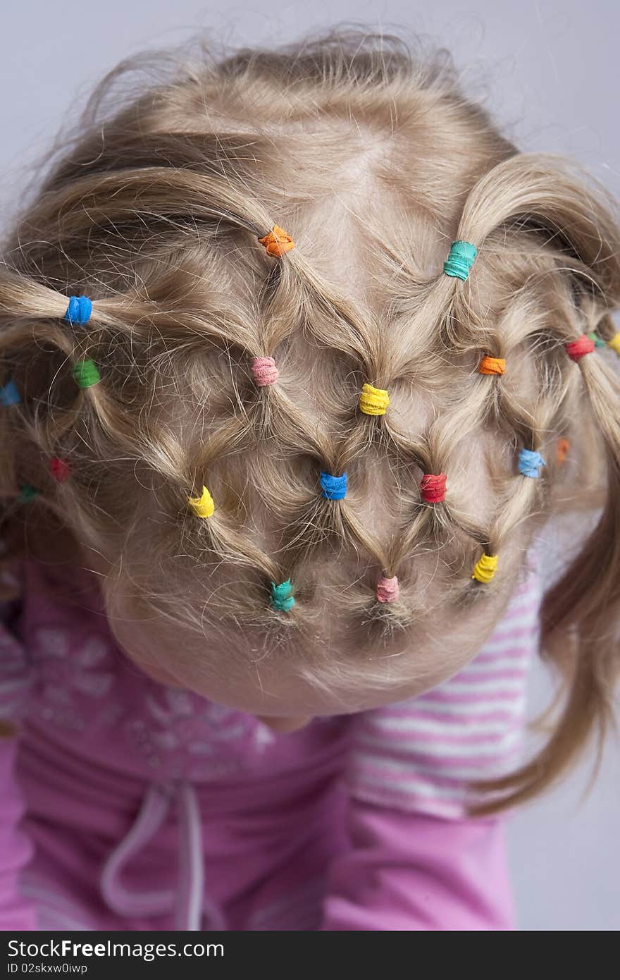 Head of young blond caucasian girl with unique hair tails design and pattern. from above view. isolated