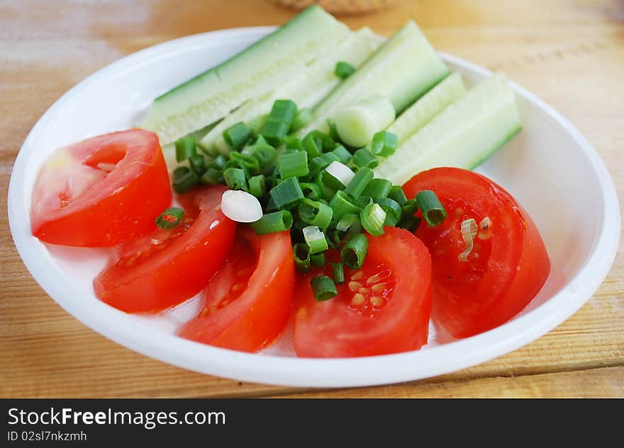 Frech cut vegetables on the plate with green onion. Frech cut vegetables on the plate with green onion.