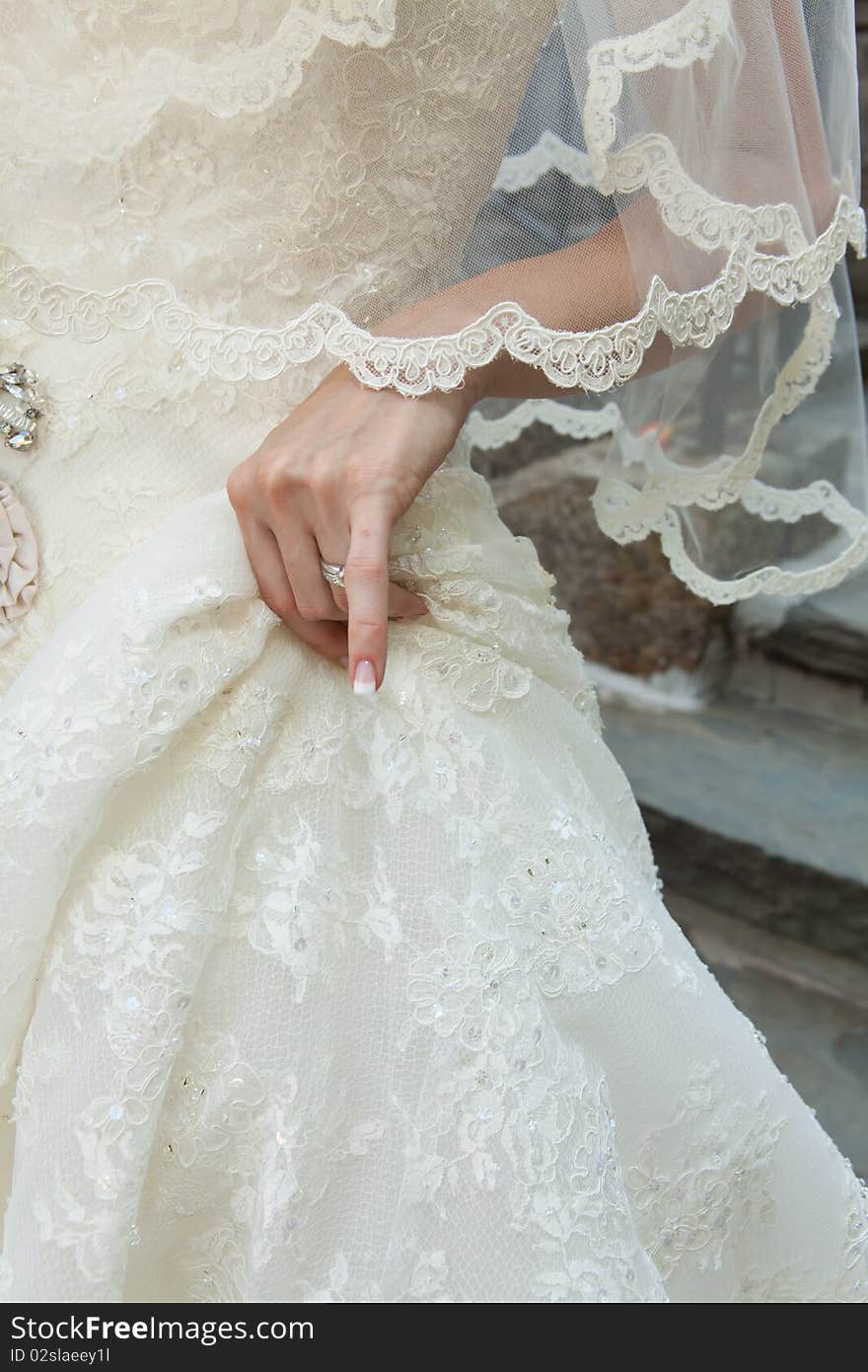 A bride holds her dress. A bride holds her dress