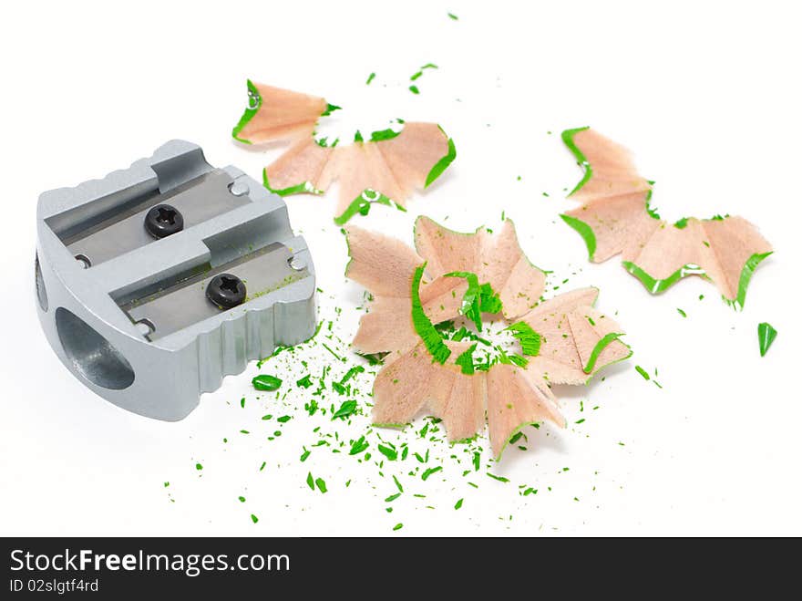 Silver sharpener with green pencil shavings. Silver sharpener with green pencil shavings