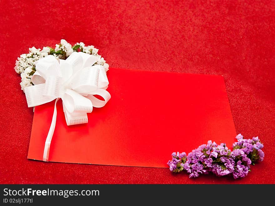 Greeting card with bow and flowers on red background