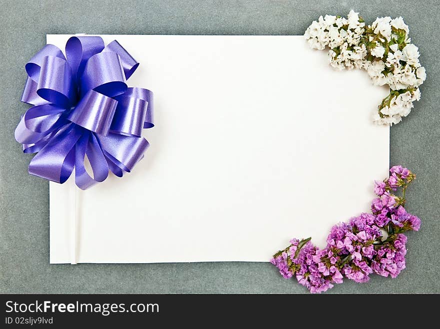 Greeting card with blue bow and flowers on grey background