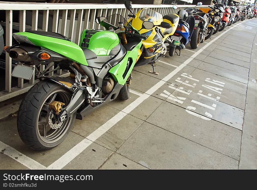 Line of motorbikes neatly parked on allocated spots on the footpath, Brisbane, Australia. Line of motorbikes neatly parked on allocated spots on the footpath, Brisbane, Australia