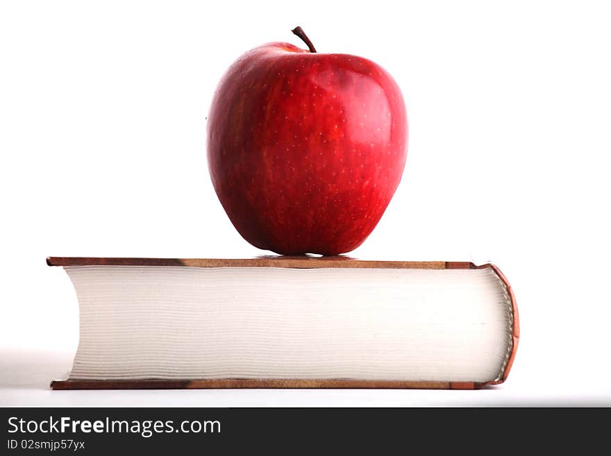 Red apple on the big book on white background