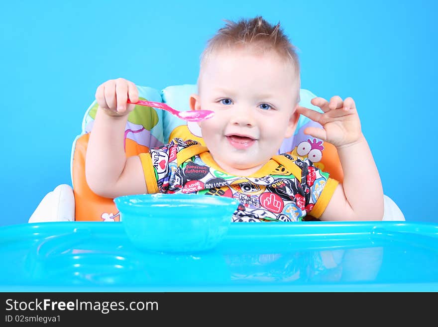 A child sits in a chair for feeding and eating. A child sits in a chair for feeding and eating