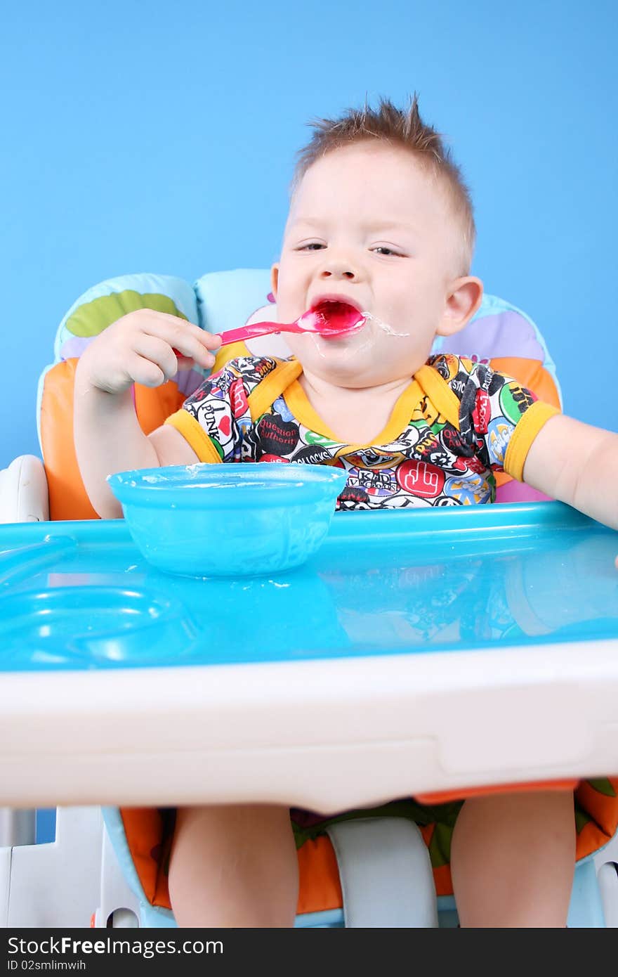 A child sits in a chair for feeding and eating. A child sits in a chair for feeding and eating