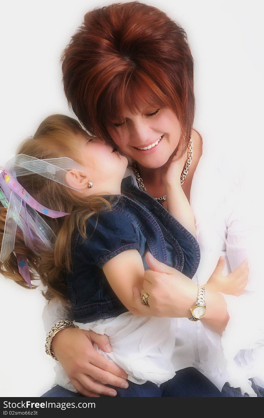 Mother and daughter kissing and smiling