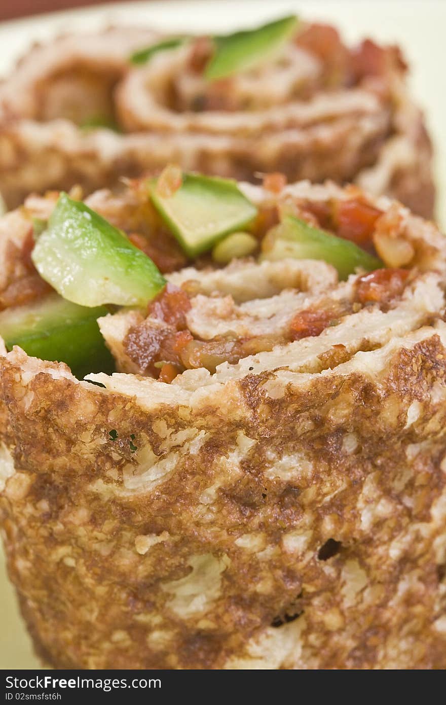 Close-up of a rolled pancake with salsa inside.