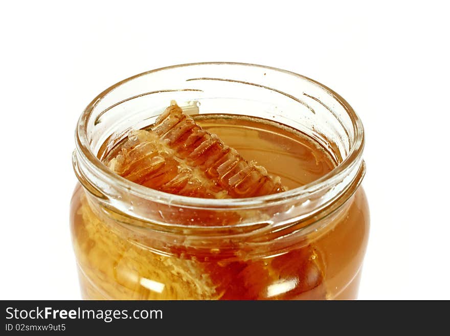 Glass jar full of honey with honeycomb, isolated on white. Glass jar full of honey with honeycomb, isolated on white