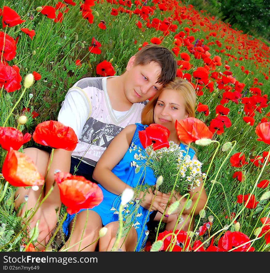 Loving couple is lying in the poppy field