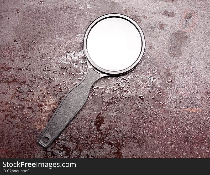 Magnifying glass on the rusty metal background. Magnifying glass on the rusty metal background