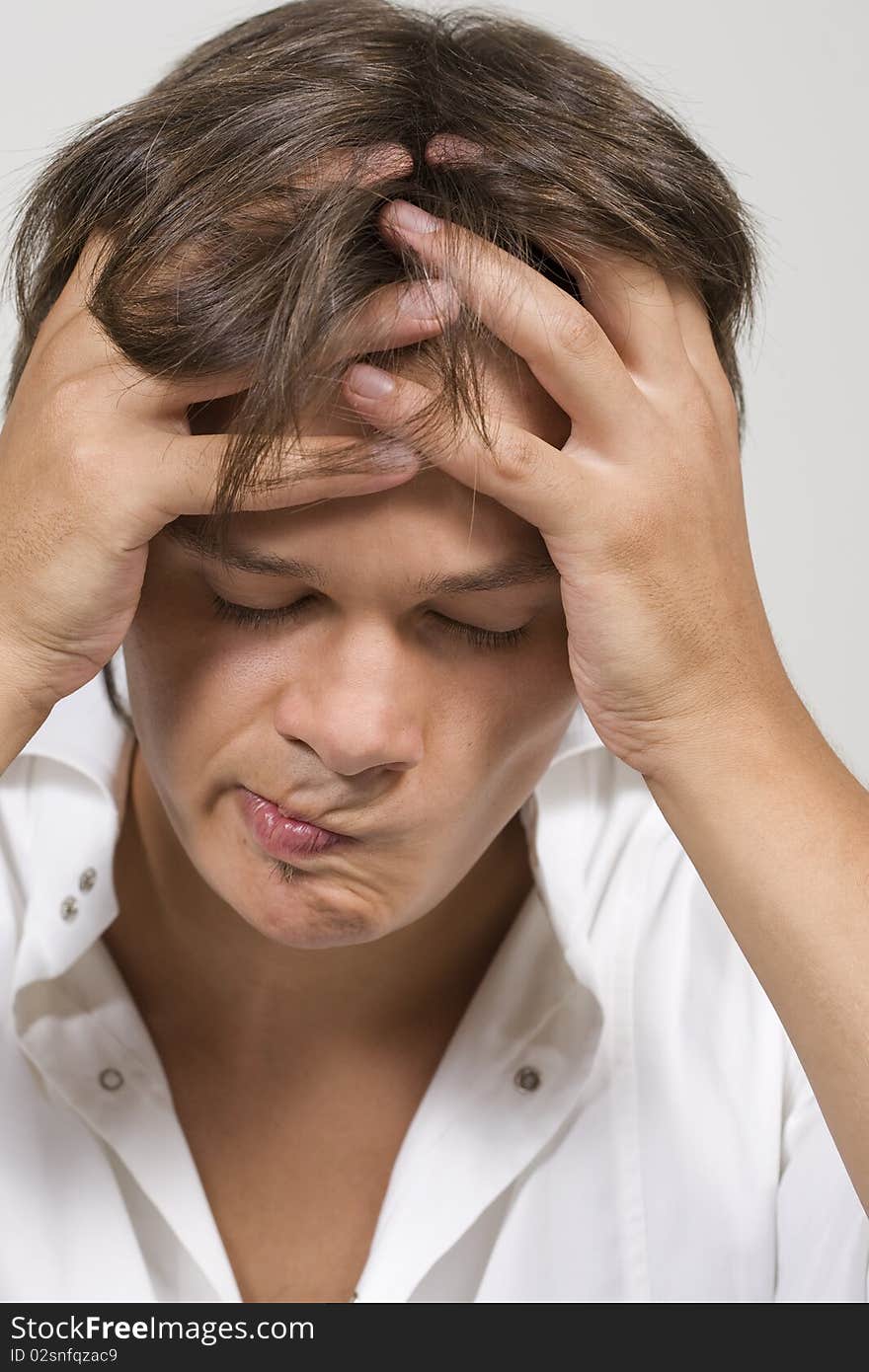 Closeup portrait of a upset young man with hand on his head