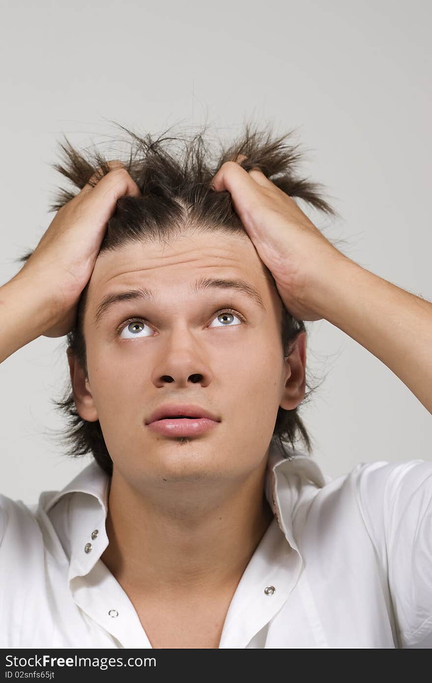 Closeup portrait of a upset young man with hand on his head