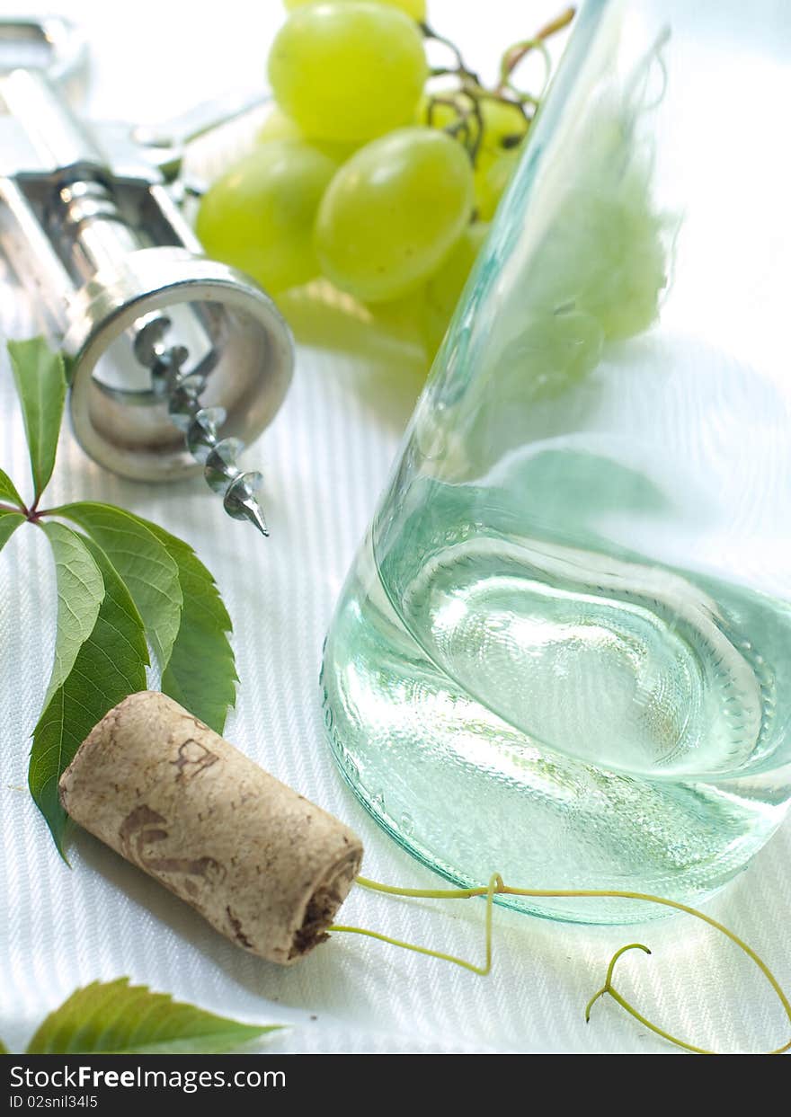 Corkscrew, cork and bottle of white wine. Corkscrew, cork and bottle of white wine.