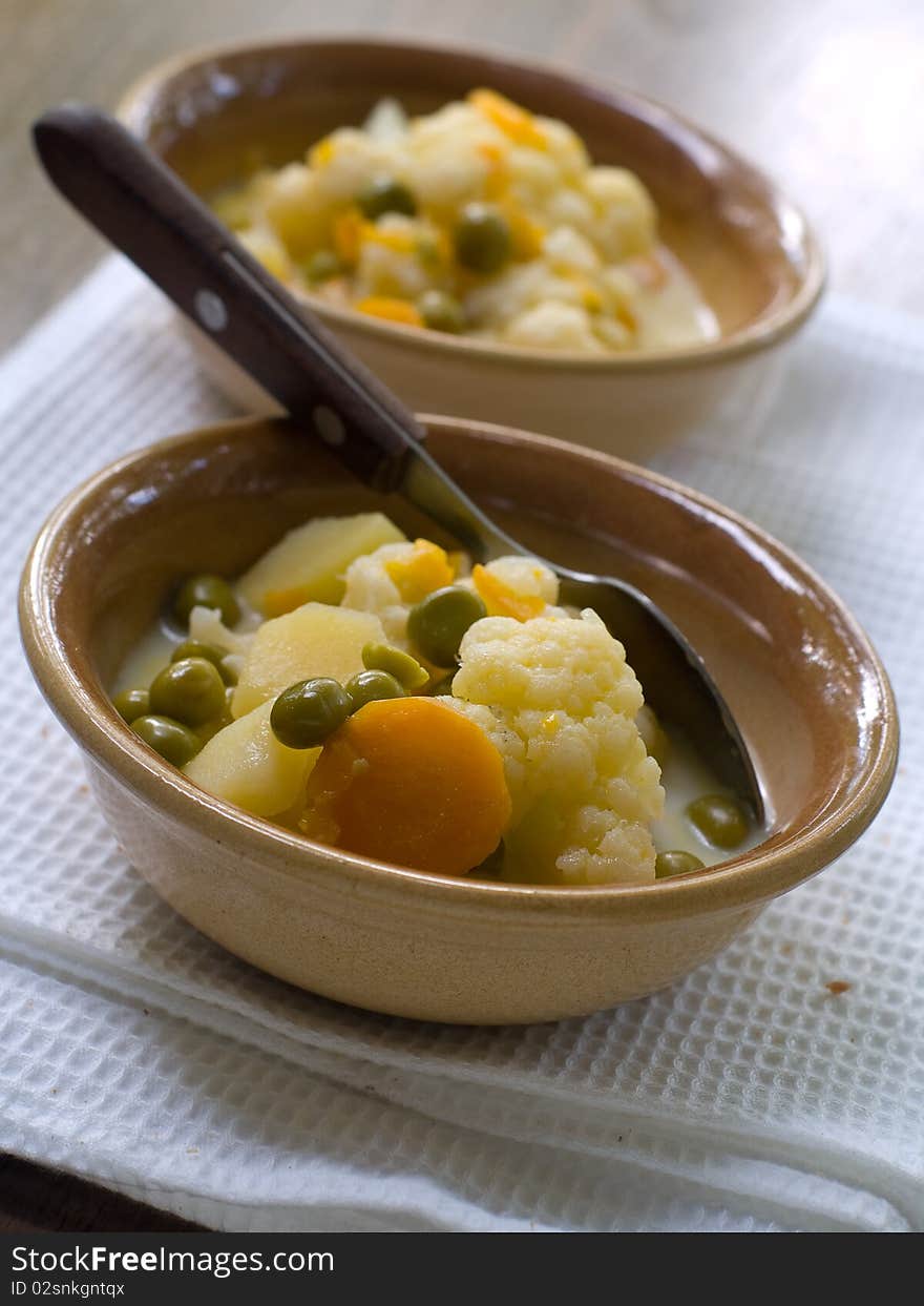 Bowl of vegetable soup on kitchen towel