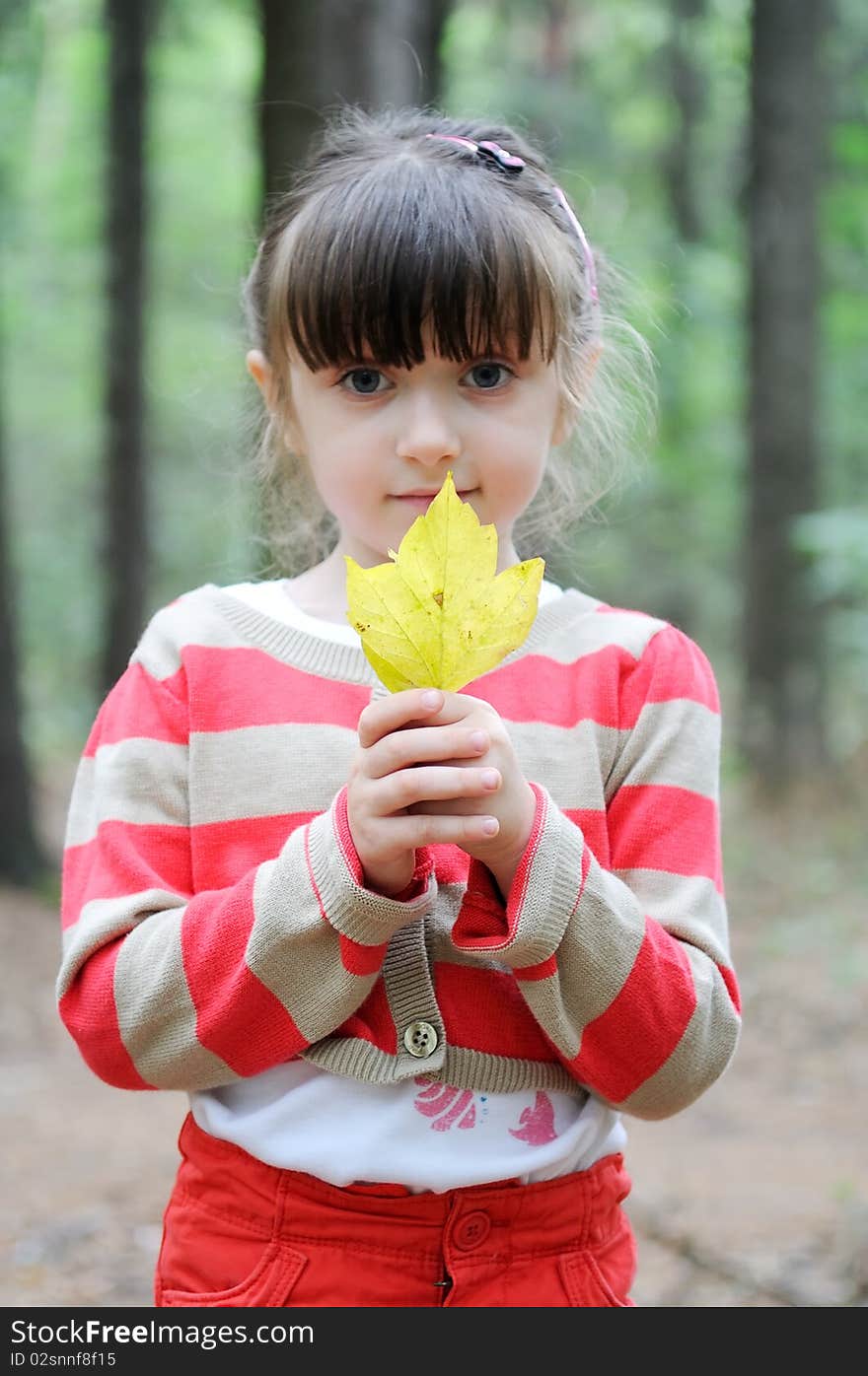 Nice toddler girl with yellow leave