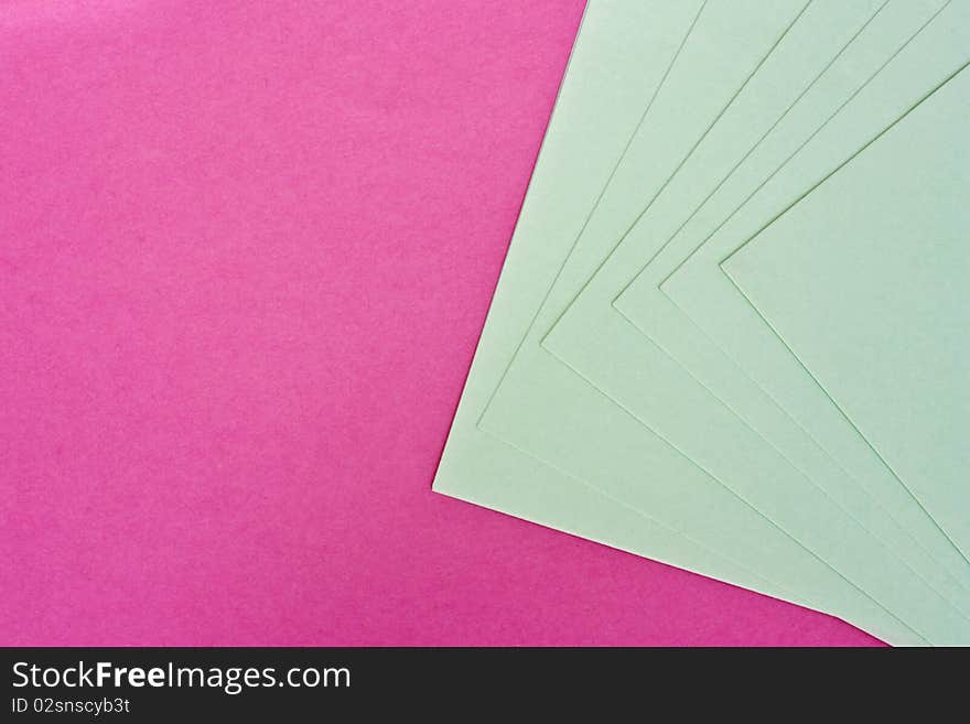 a background of pink and white paper spread out to form a pattern. a background of pink and white paper spread out to form a pattern