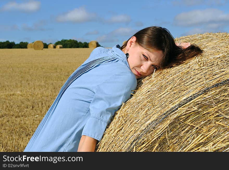 Young woman near the straw bales. England.