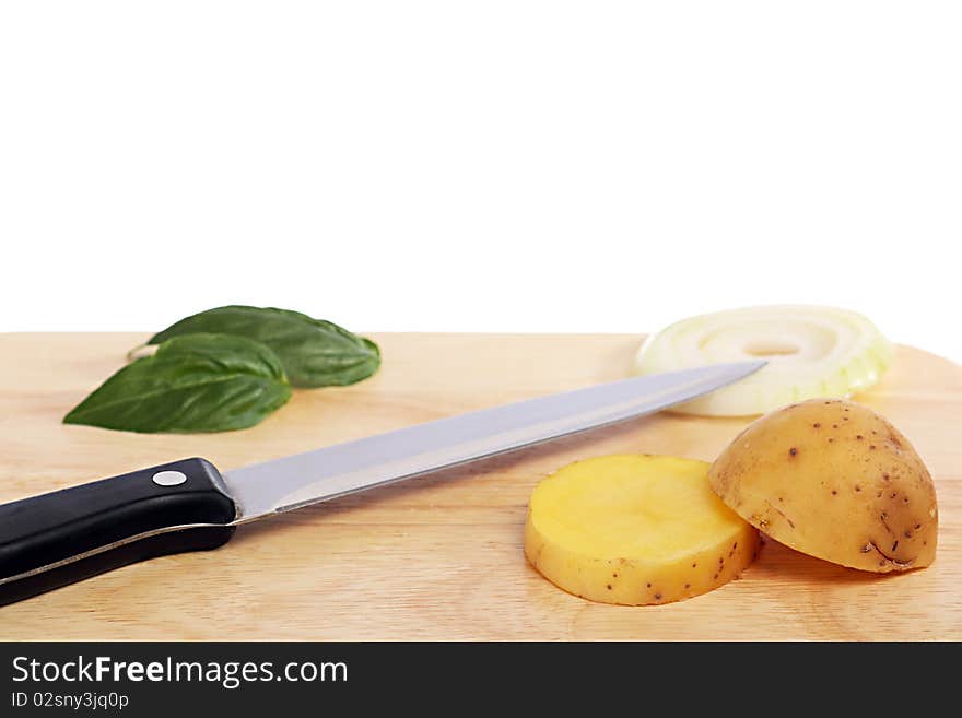 Knife next to potatoes, onions and basil. Knife next to potatoes, onions and basil