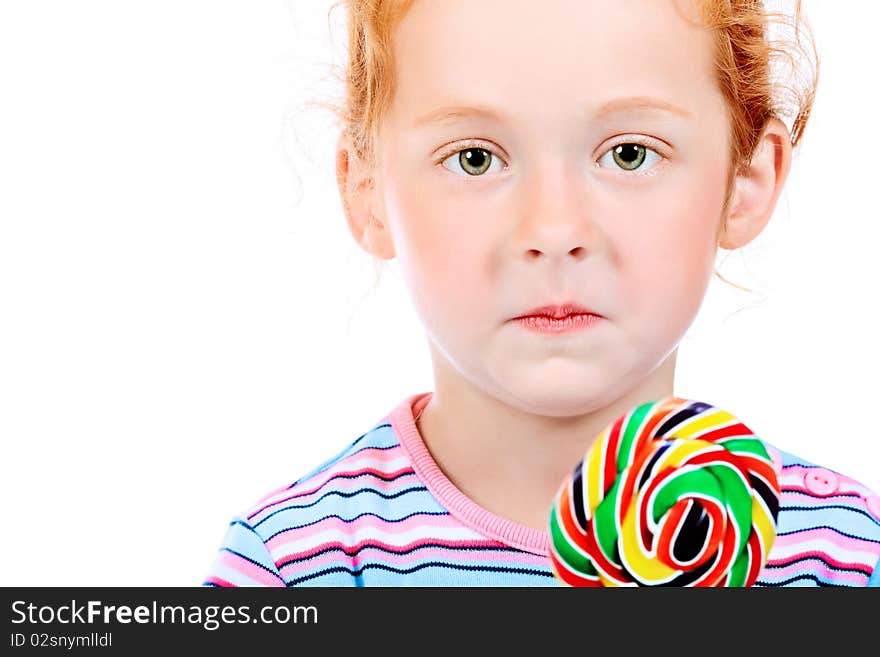 Portrait of a little red-haired girl licking lollipop. Isolated over white background. Portrait of a little red-haired girl licking lollipop. Isolated over white background.