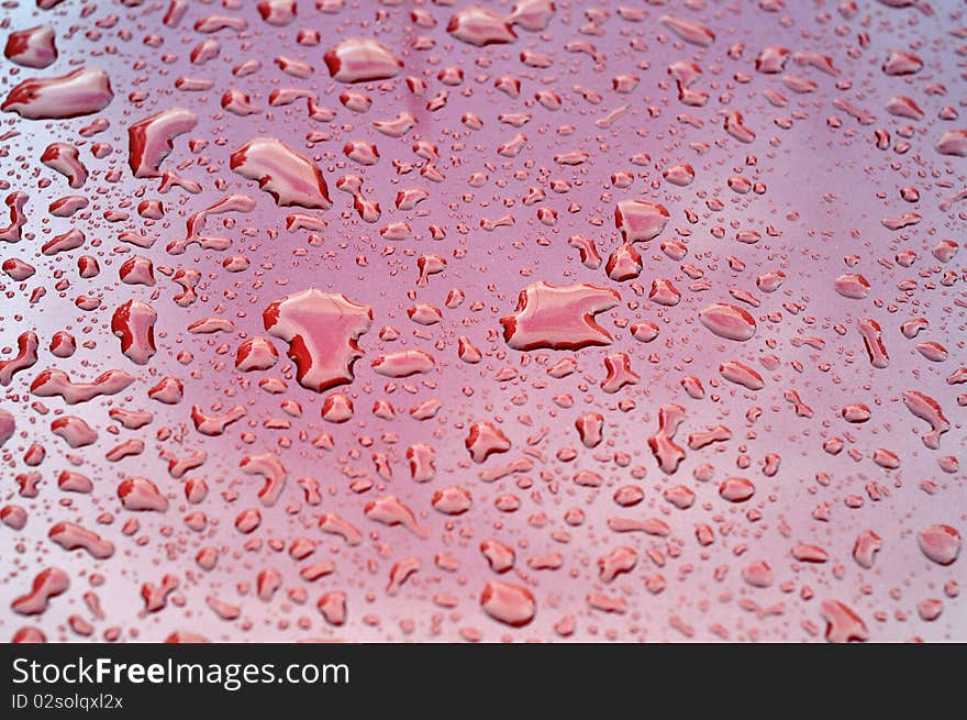 Abstract red toned photo of water drops on a clean car surface. Abstract red toned photo of water drops on a clean car surface.