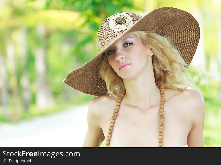 Outdoor portrait of a young beautiful woman in hat