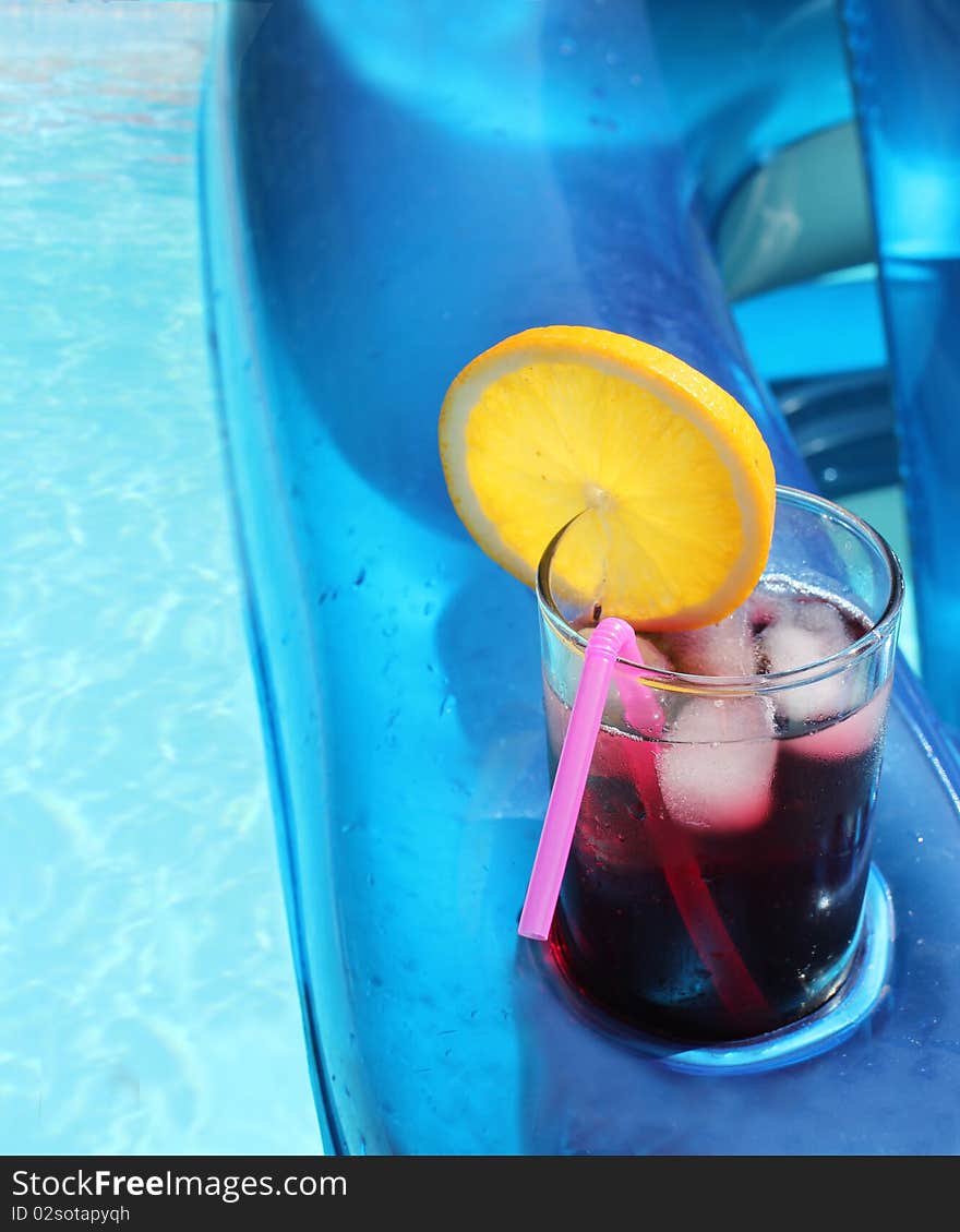 Refreshing summer drink in an inflatable chair relaxing in the pool