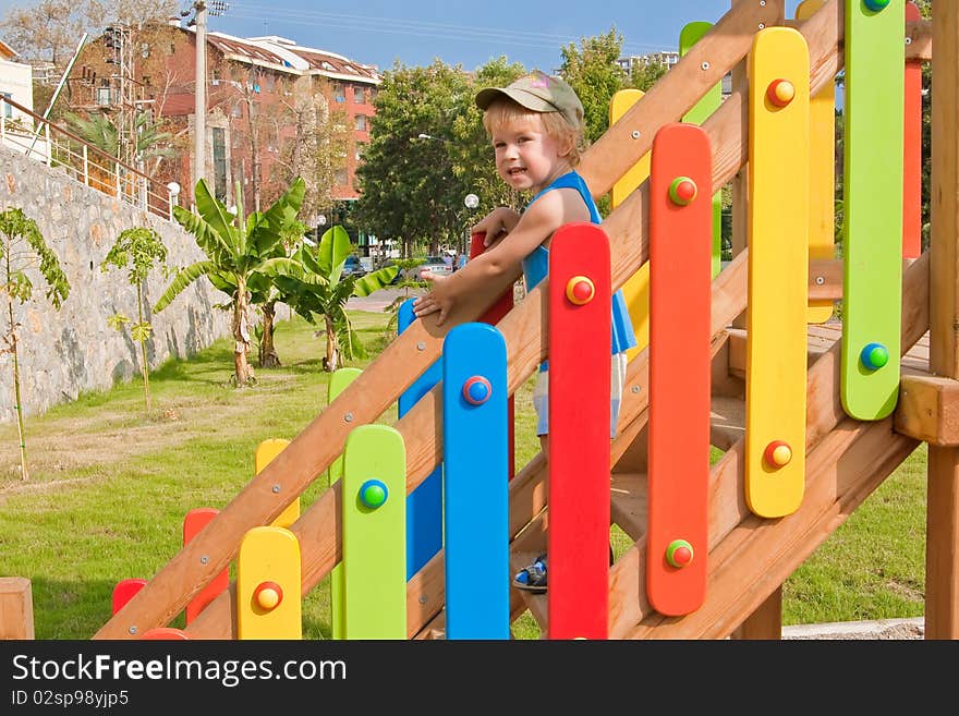 Kid descending from the stairs on the coloring playground. Kid descending from the stairs on the coloring playground