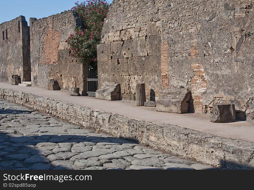 A paved street in the ruined town of Pompeii at the foot of Mount Vesuvius. A paved street in the ruined town of Pompeii at the foot of Mount Vesuvius