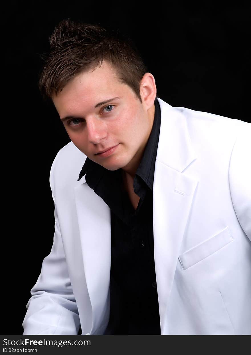 Portrait of young businessman over black background