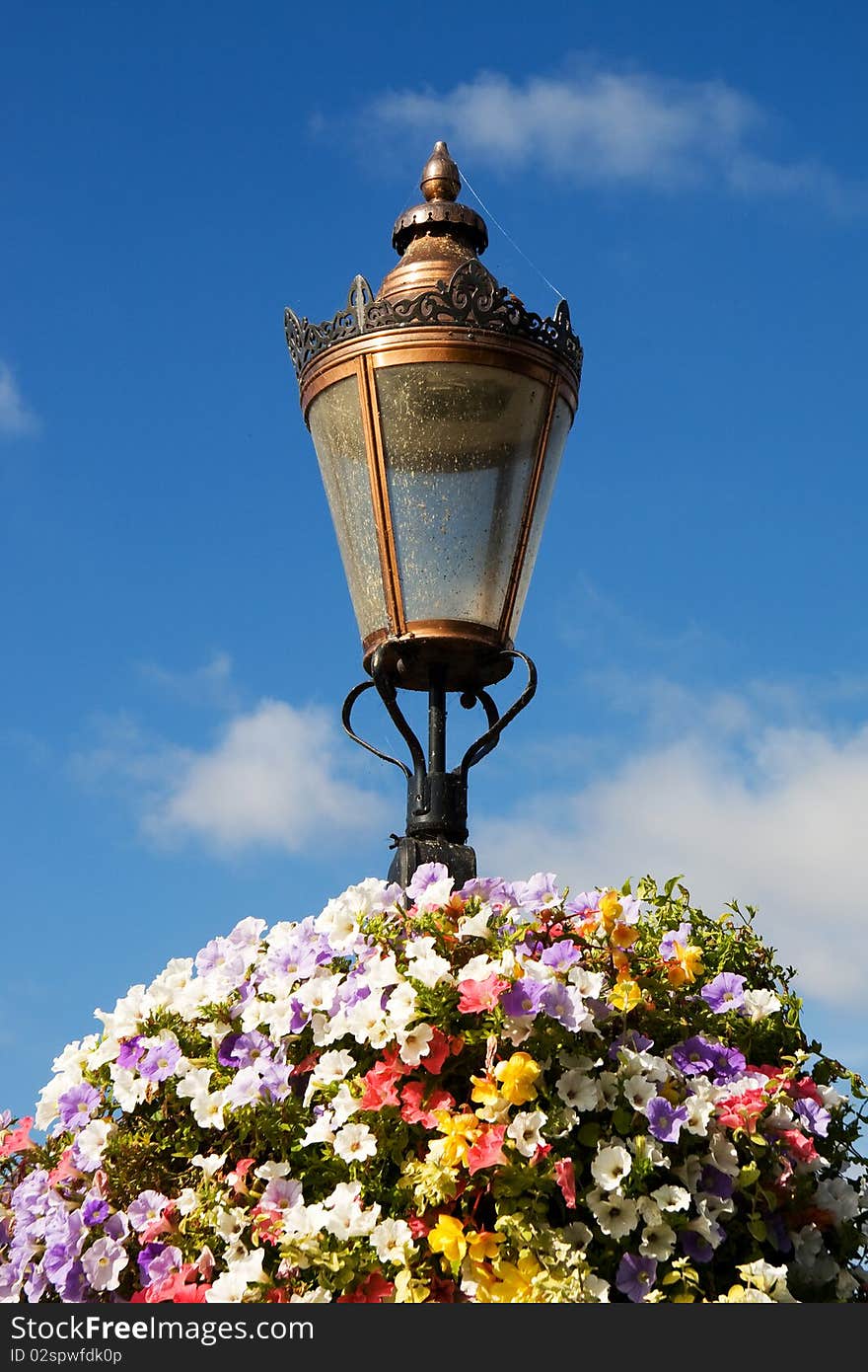 A light-post decorated with flowers. A light-post decorated with flowers