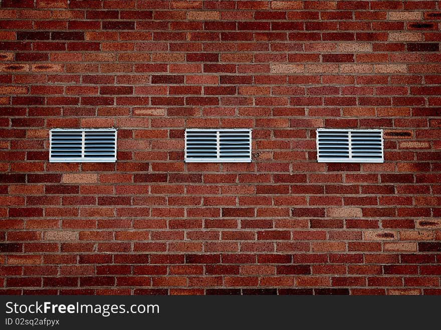 Detail shot of an old brick wall with metal vents. Detail shot of an old brick wall with metal vents