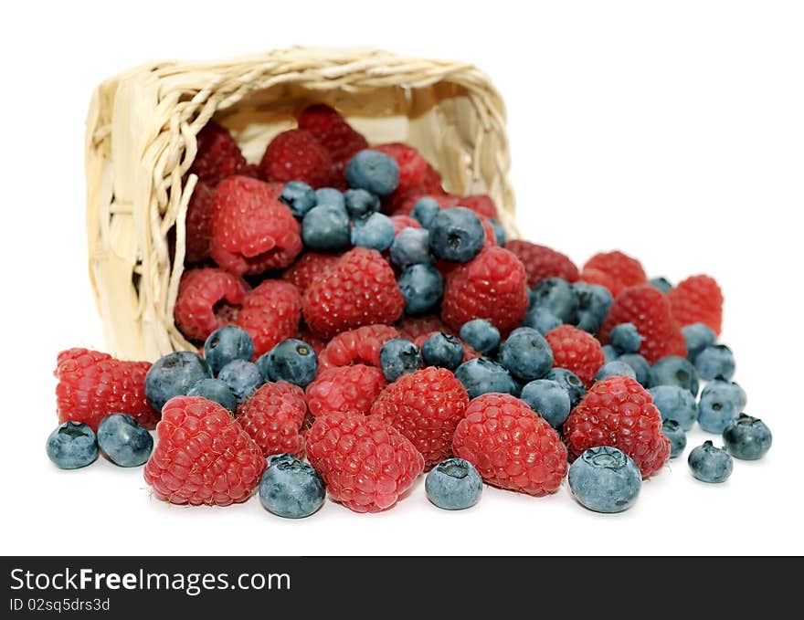 Raspberries, blueberries and wicker basket.