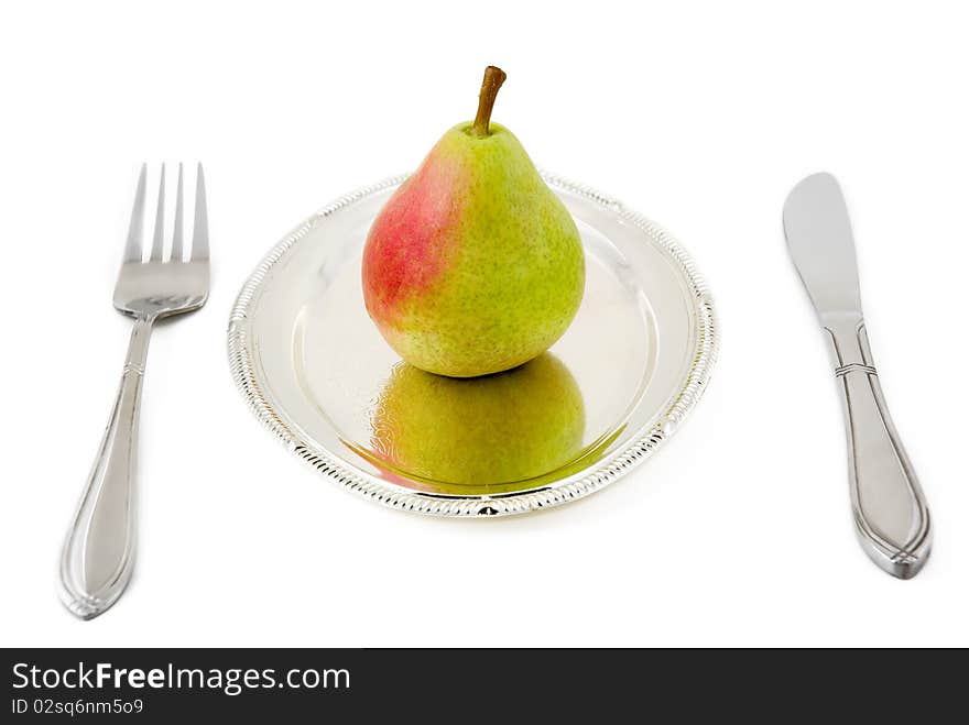 Pear on a silver plate are photographed on the white background