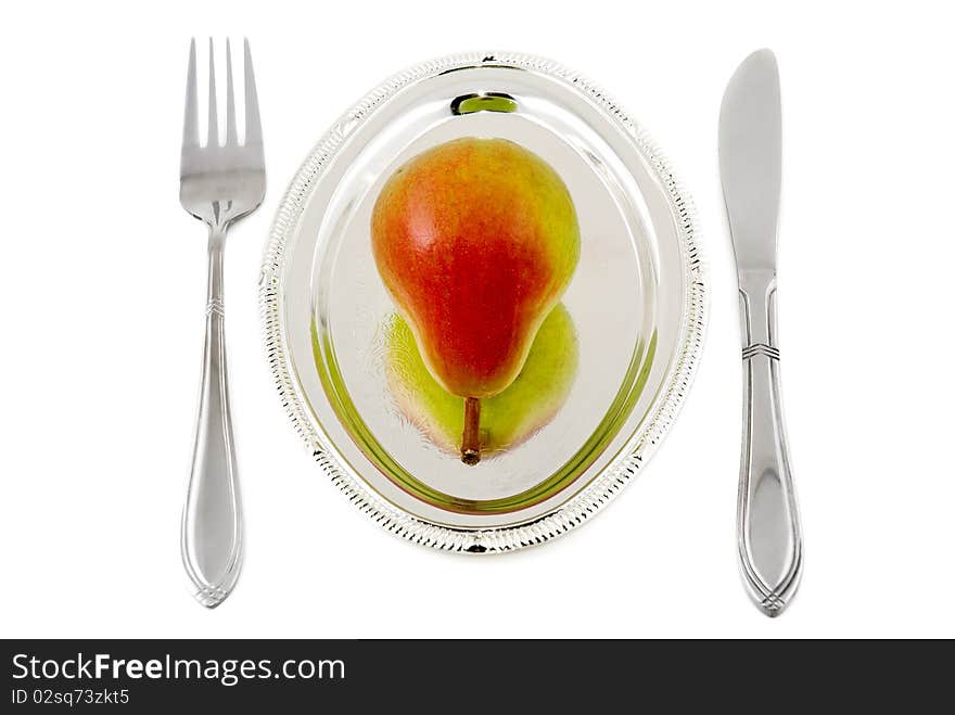 Pear on a silver plate are photographed on the white background