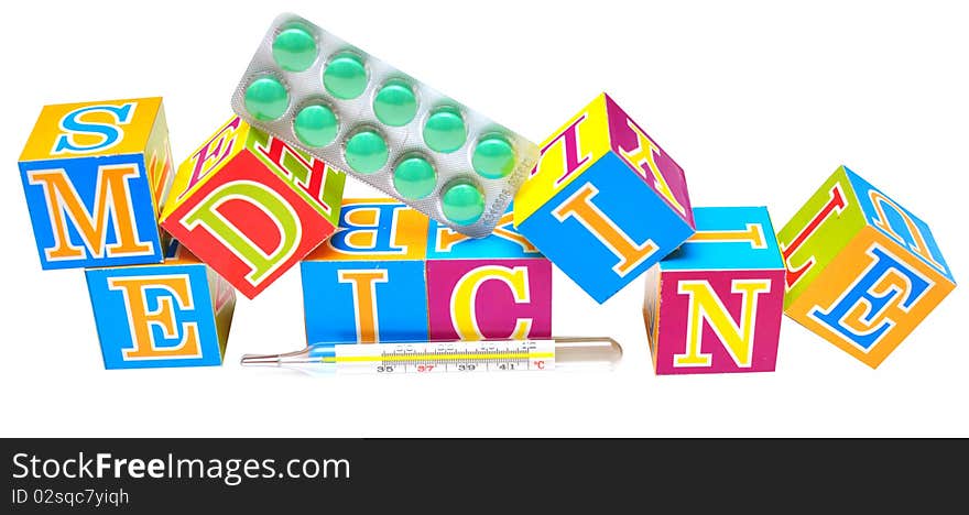 Thermometer in front of some cubes with the word medicine. Thermometer in front of some cubes with the word medicine