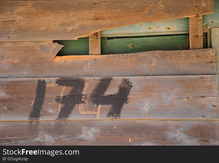 Painted gate number on wooden wall