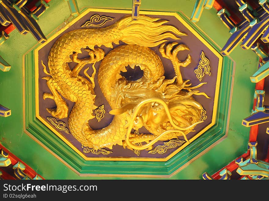 A golden dragon in chinese style. On ceiling.