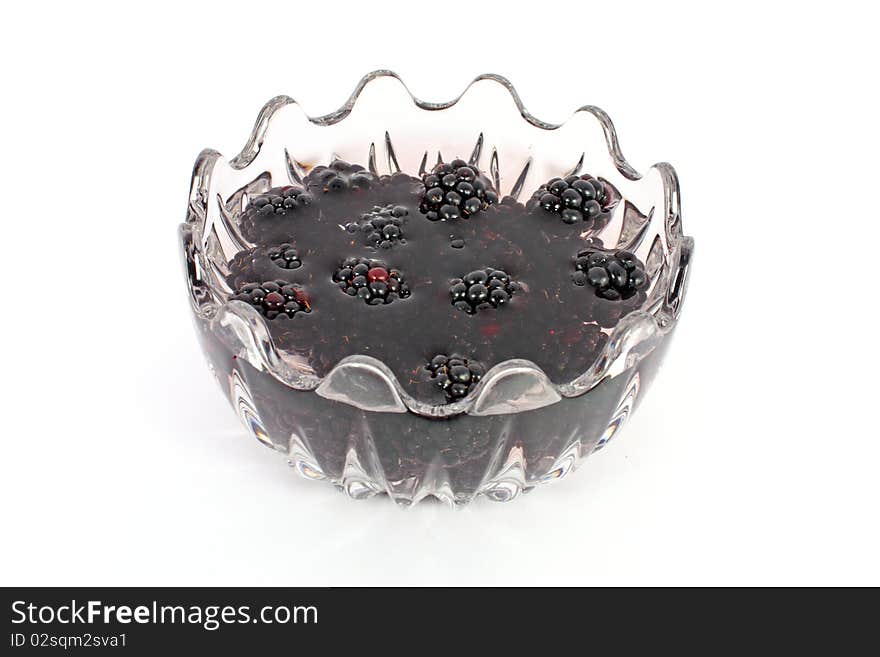 Compote of blackberries in glass bowl isolated on white